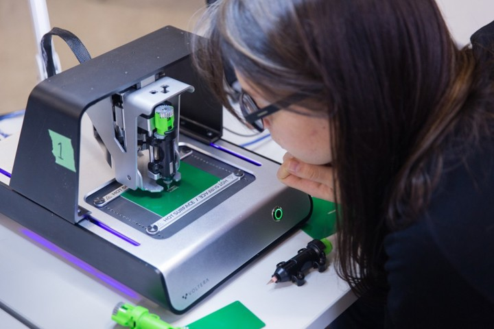 An image of a young lady using the voltera machine to print a circuit board